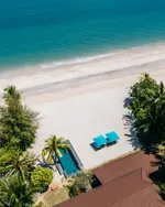 Aerial view of Four Seasons Resort Langkawi beachfront with a private pool, palm trees, sun loungers, and turquoise sea.