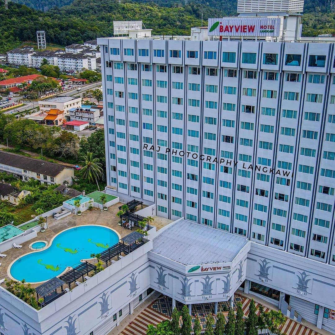 Bayview Hotel Langkawi featuring a modern high-rise hotel with a rooftop outdoor swimming pool, spacious city-view accommodations, and a convenient location in Kuah Town surrounded by hills and urban attractions.
