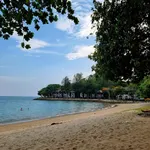 Quiet beach at Rebak Island Resort Langkawi with calm sea, shaded trees, and beachfront villas along the shoreline.