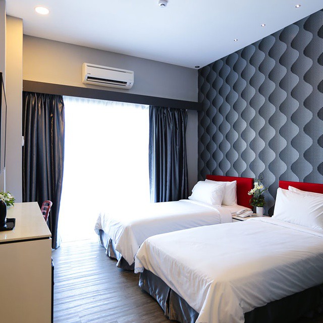 Cenang Plaza Beach Hotel Langkawi featuring a modern twin guest room with comfortable beds, contemporary geometric wall décor, floor-to-ceiling windows, and a bright, minimalist interior.