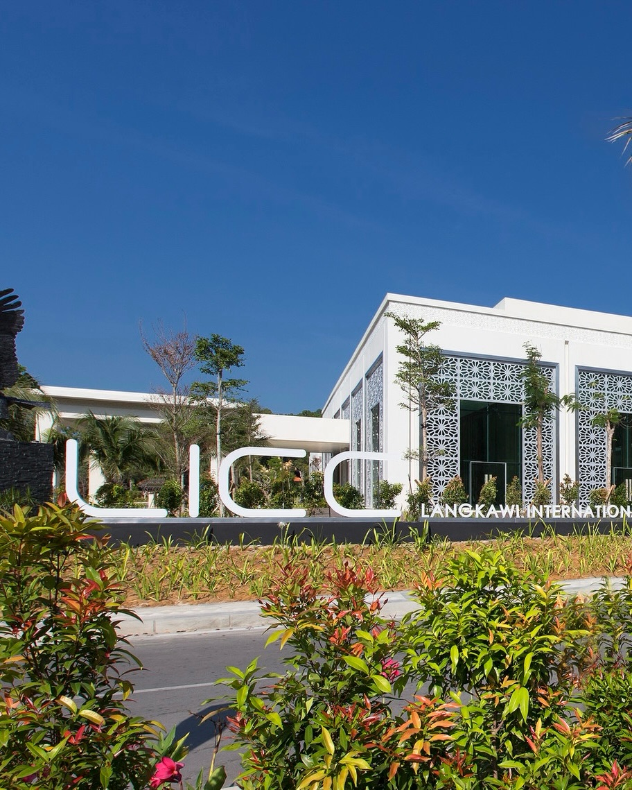 De Langkawi Resort & Convention Centre featuring a contemporary white architectural complex with elegant geometric façade details, landscaped tropical gardens, and a welcoming entrance near Langkawi International Airport.