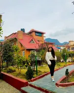 Dream Garden Resort Langkawi featuring charming cottage-style accommodations with red roofs, landscaped gardens, a paved walking path, and scenic mountain views in a peaceful tropical setting.