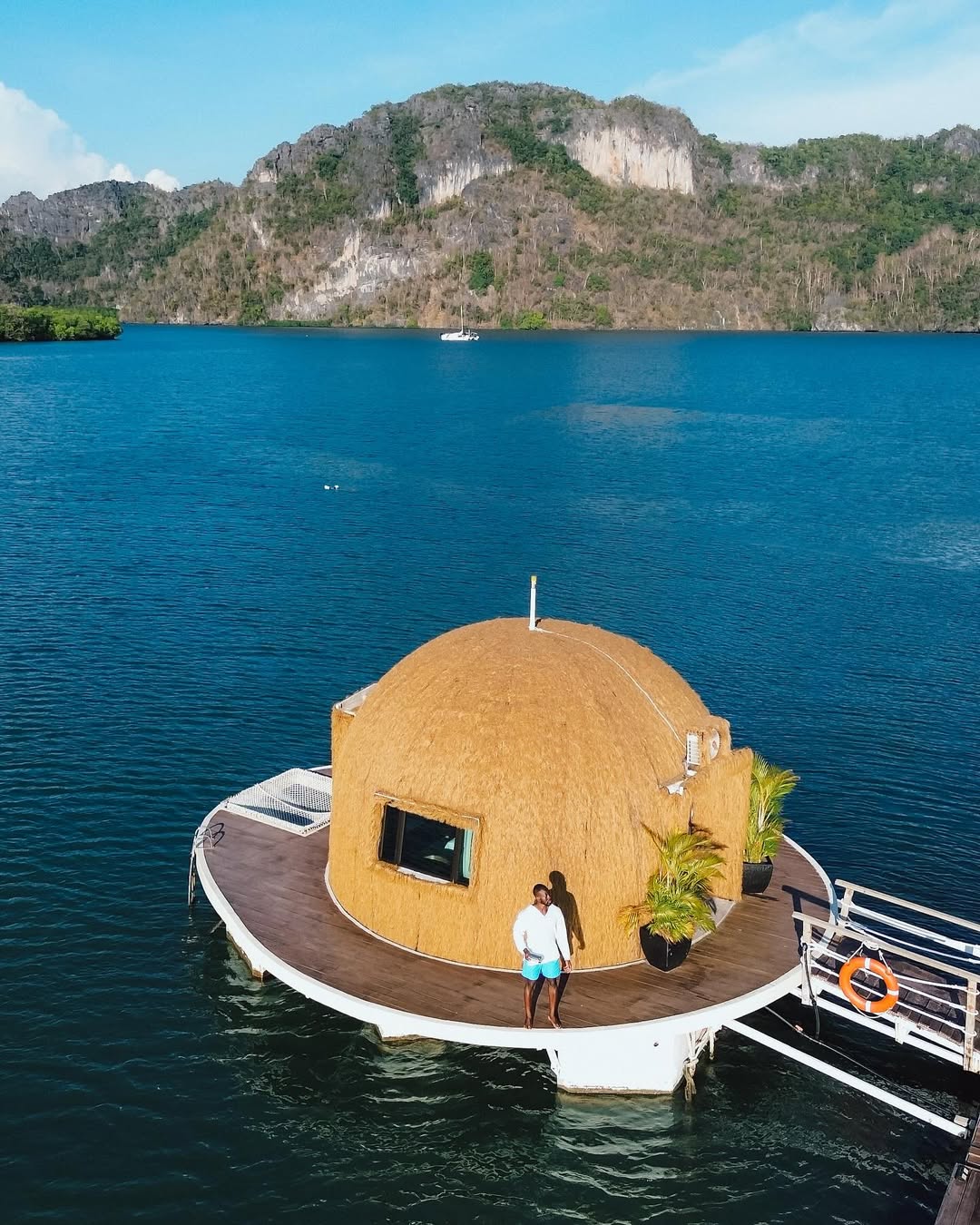 Floating coconut-shaped bungalow in Tanjung Rhu Langkawi surrounded by calm blue sea with limestone hills in the background.