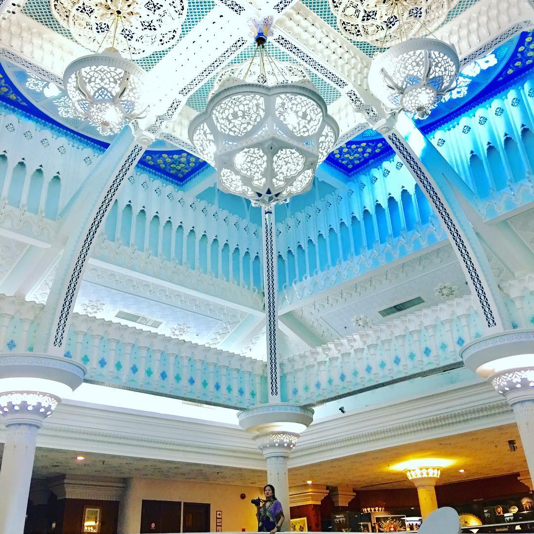 Grand Continental Langkawi featuring a grand hotel lobby with elegant Islamic-inspired architecture, ornate white chandeliers, intricate decorative ceilings, blue accents, and a spacious atrium creating a luxurious atmosphere.
