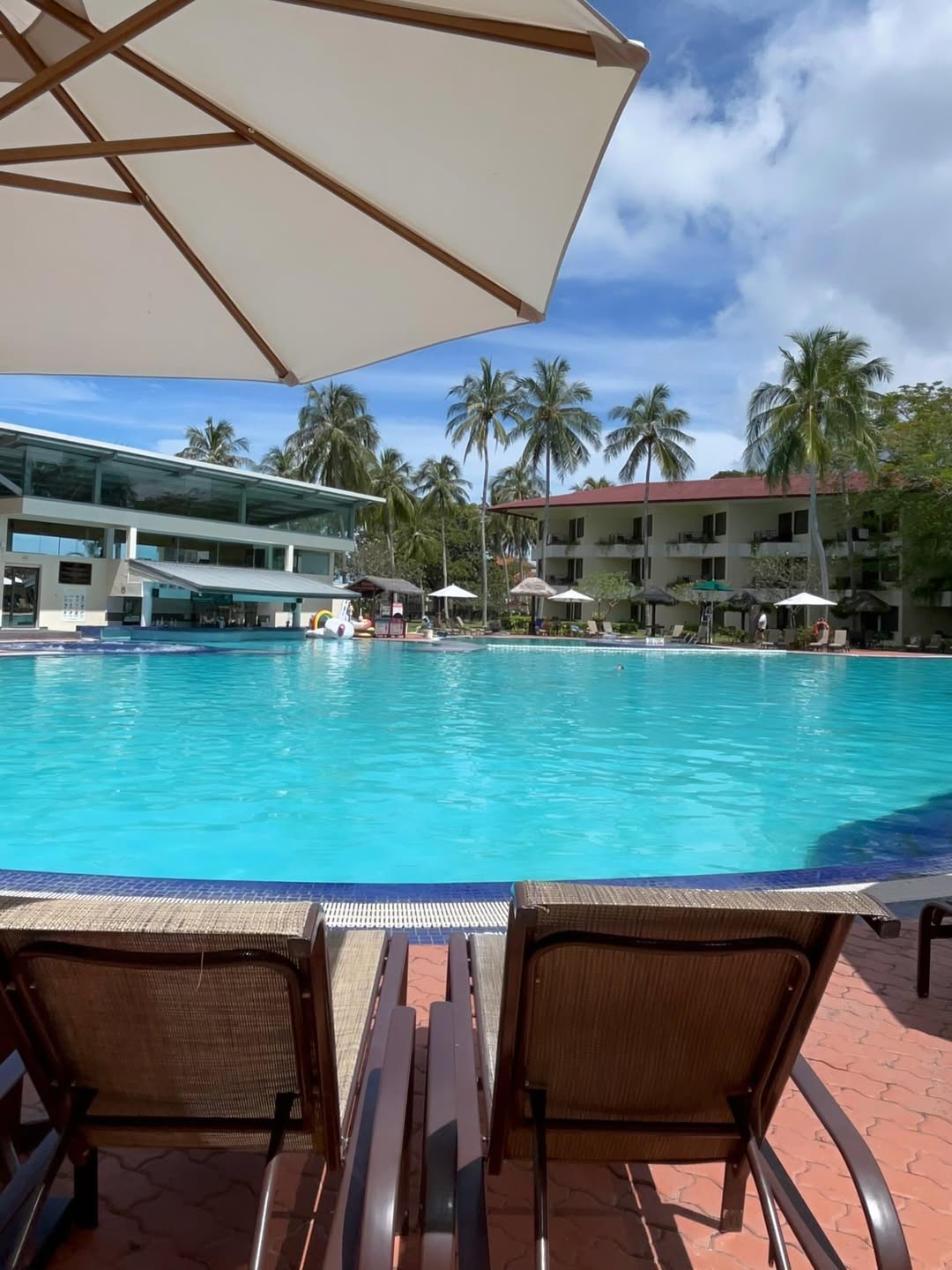 Holiday Villa Resort & Beachclub Langkawi featuring a large freeform outdoor swimming pool surrounded by palm trees, sun loungers, tropical gardens, and low-rise beachfront accommodations near Pantai Tengah.