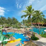 Kids’ water play area at Pelangi Beach Resort Langkawi with slides, splash features, palm trees, and a pool nearby.