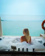 Person relaxing in a bubble bath at Berjaya Langkawi Resort overlooking the calm turquoise sea.