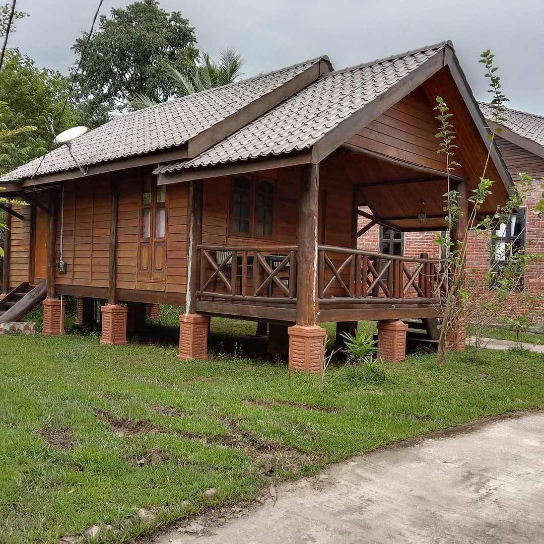 Padimas Villa @ Datai Valley Langkawi featuring a traditional Malay-style wooden villa on stilts with a covered front veranda, rustic timber architecture, and a peaceful garden setting surrounded by lush tropical greenery.