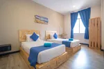 Paretto Seaview Hotel Langkawi featuring a bright and modern twin guest room with handcrafted wooden furniture, blue accents, large windows, and a clean, comfortable minimalist design.