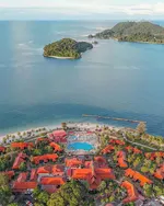 Aerial view of Pelangi Beach Resort & Spa Langkawi with red-roofed villas, a central pool, sandy beach, and small islands in the sea.