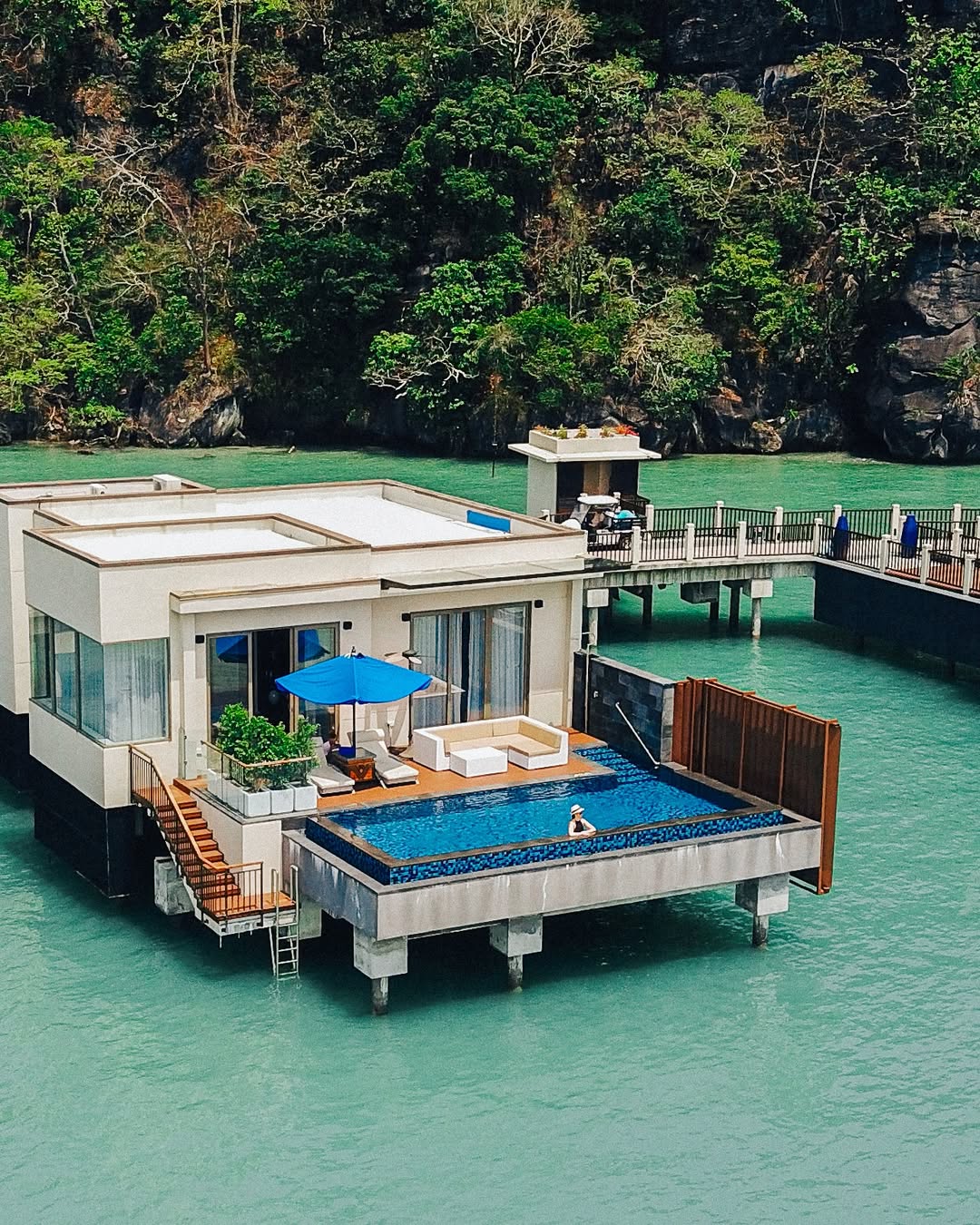 Overwater Sunset Royal Villa at The St. Regis Langkawi featuring a private infinity pool, sun deck, and direct views of turquoise sea and surrounding limestone cliffs.