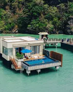 Overwater Sunset Royal Villa at The St. Regis Langkawi featuring a private infinity pool, sun deck, and direct views of turquoise sea and surrounding limestone cliffs.