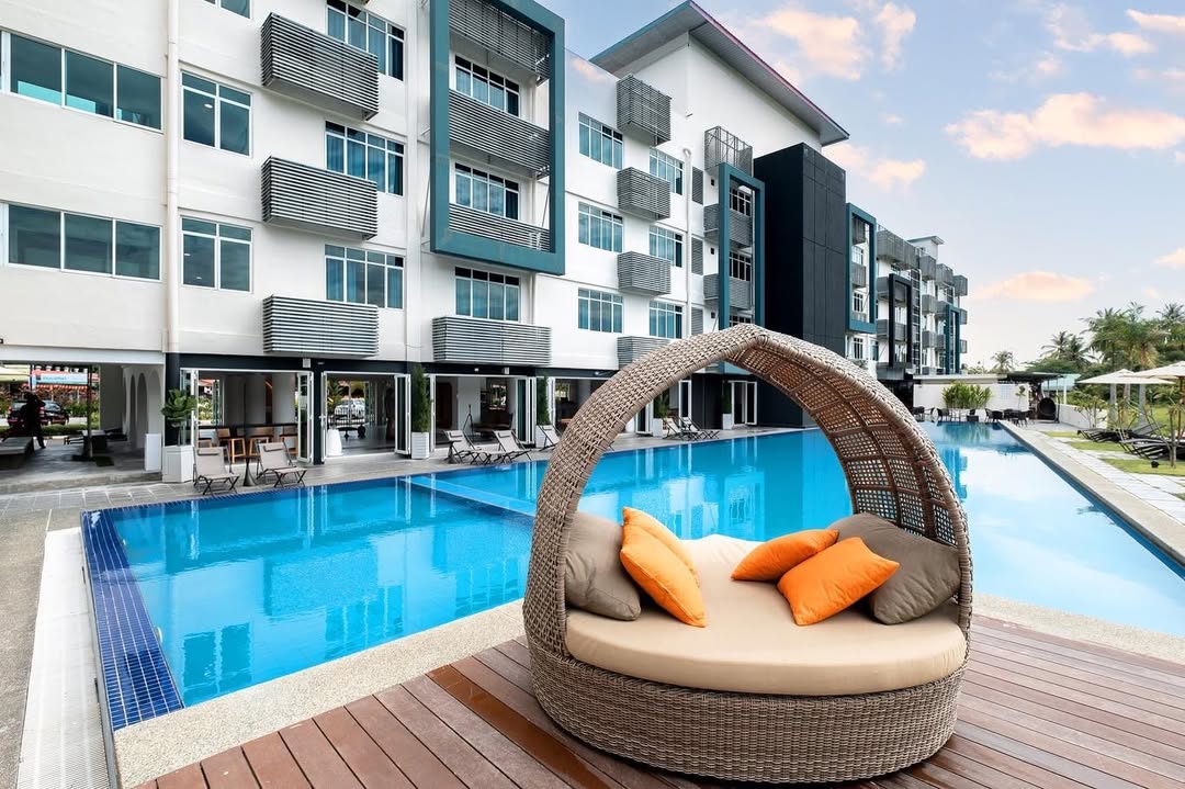 The Bayou Hotel Langkawi featuring a modern outdoor swimming pool, contemporary low-rise accommodations, stylish poolside daybeds, and a relaxing resort atmosphere near Pantai Cenang.