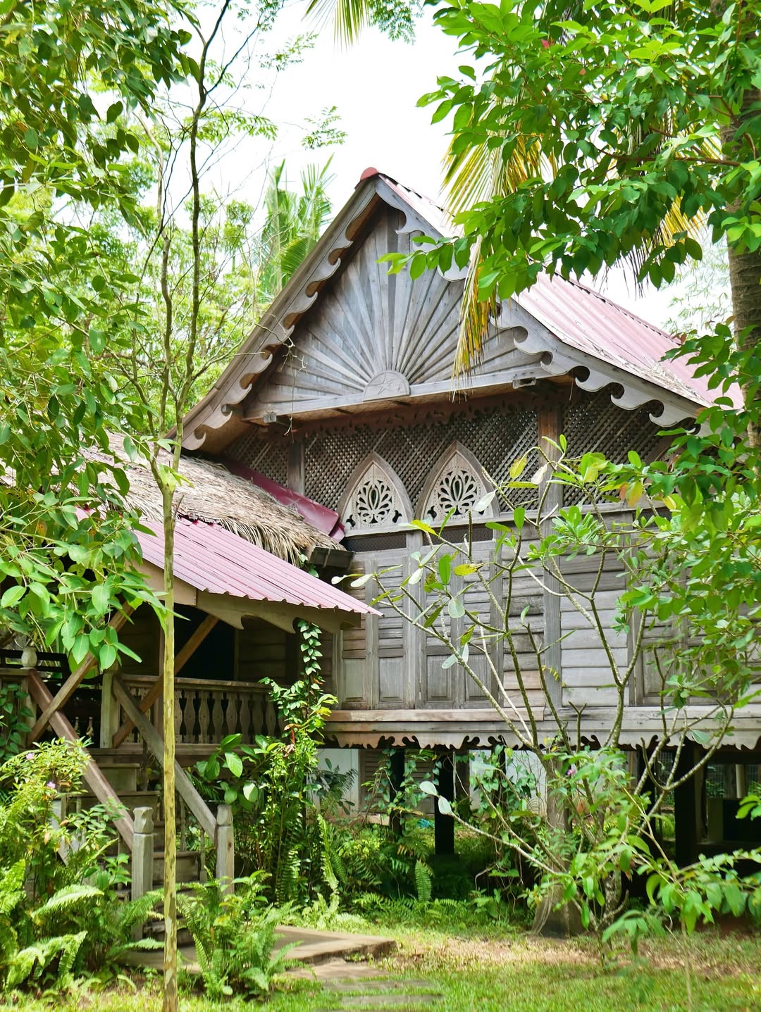 Traditional wooden Malay heritage villa surrounded by lush tropical greenery at Kunang-Kunang Heritage Villas, offering a serene nature retreat in Langkawi.