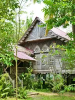 Traditional wooden Malay heritage villa surrounded by lush tropical greenery at Kunang-Kunang Heritage Villas, offering a serene nature retreat in Langkawi.